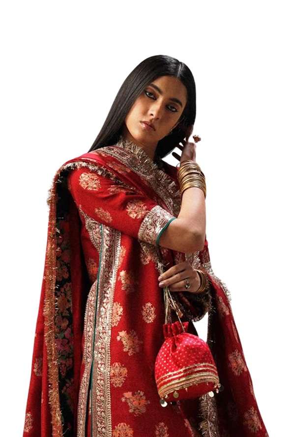 Bride draped in a deep red bandhani ensemble, holding a matching potli