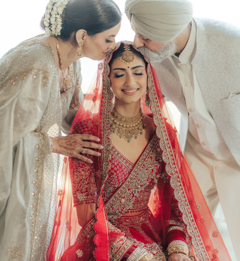 Family blessing the bride in traditional Indian celebration attire